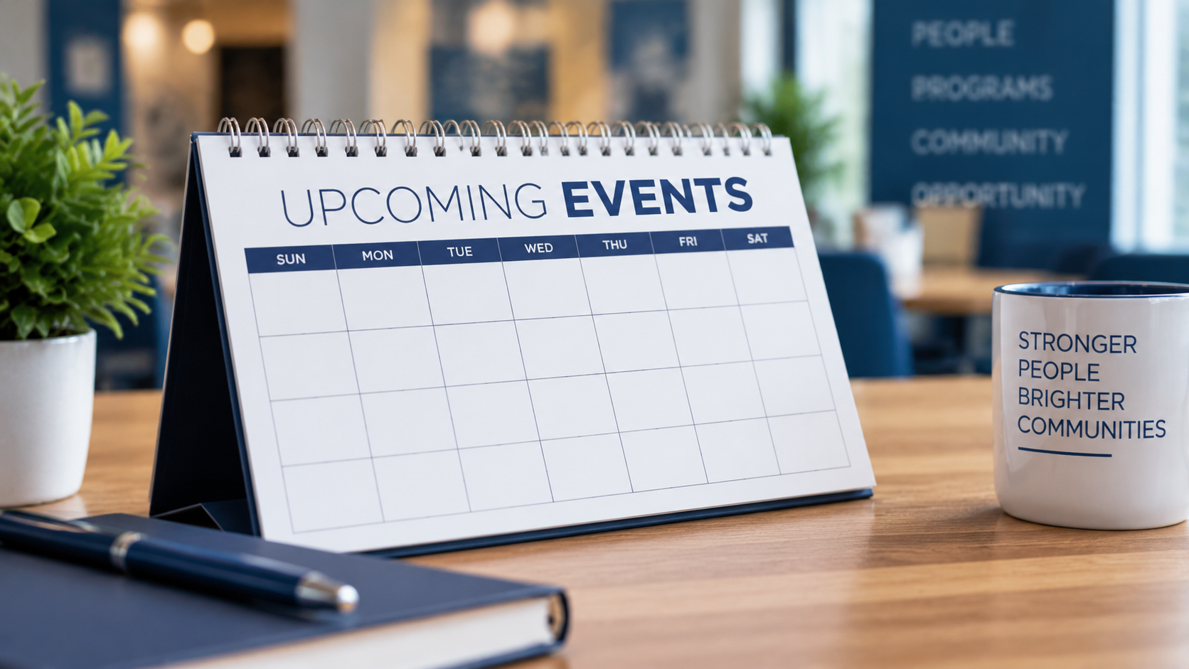 Desktop calendar labeled “Upcoming Events” on a desk with a pen, plant, and coffee mug in an office setting