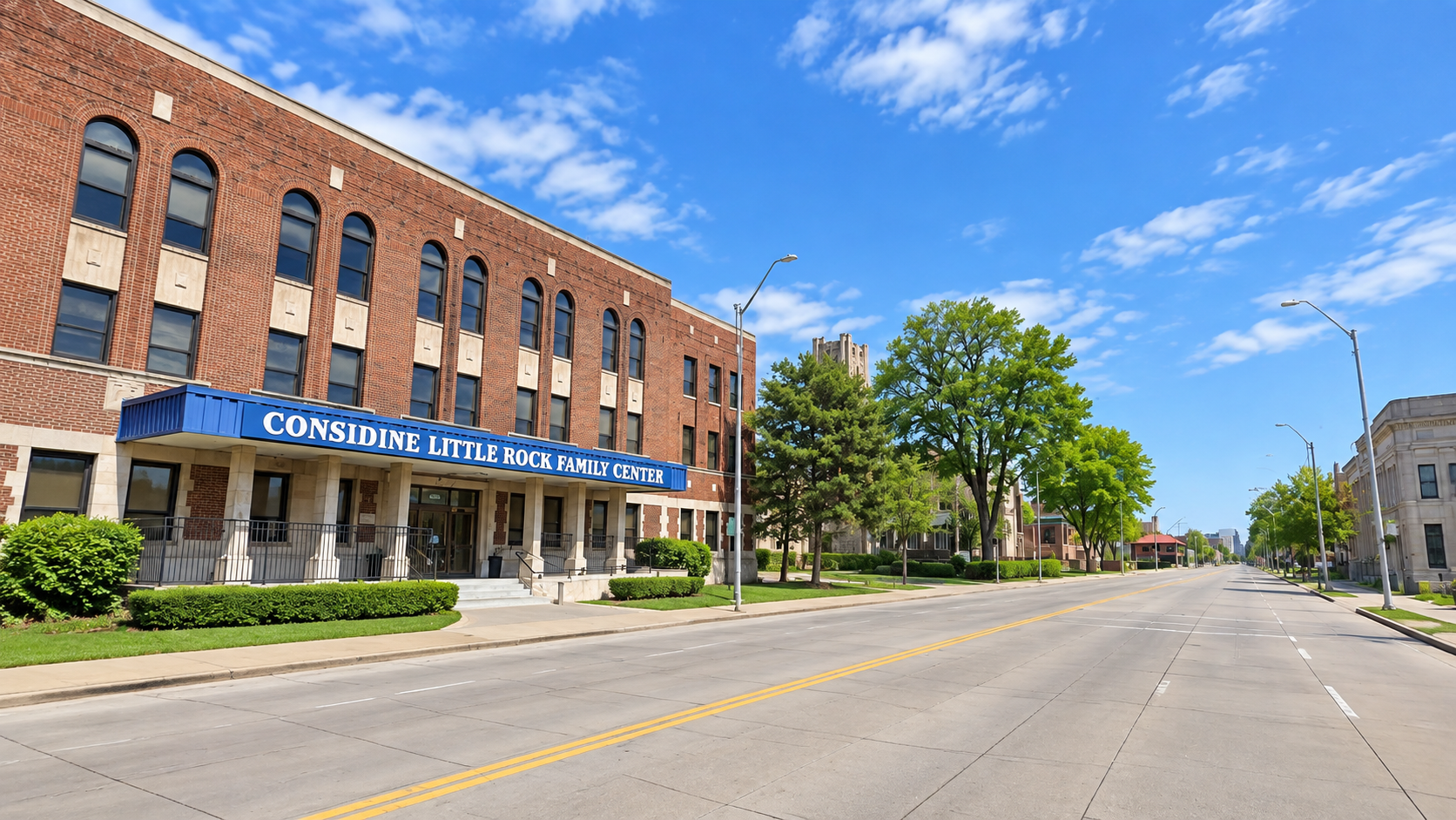 Brick commercial building on a sunny street corner with blue awning and empty road under a bright sky