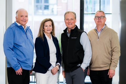 Leadership team group photo in a modern office lobby