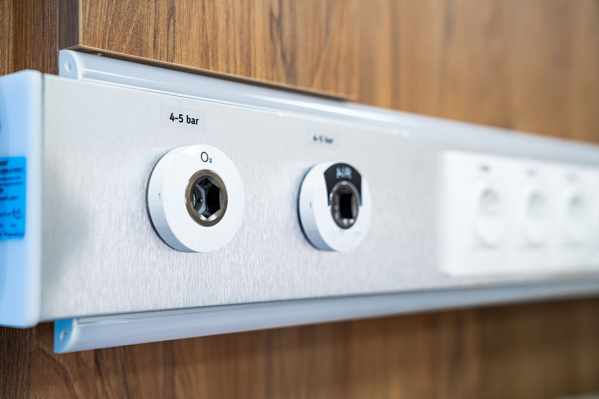 White wall-mounted double electrical outlet panel on a wood-paneled wall