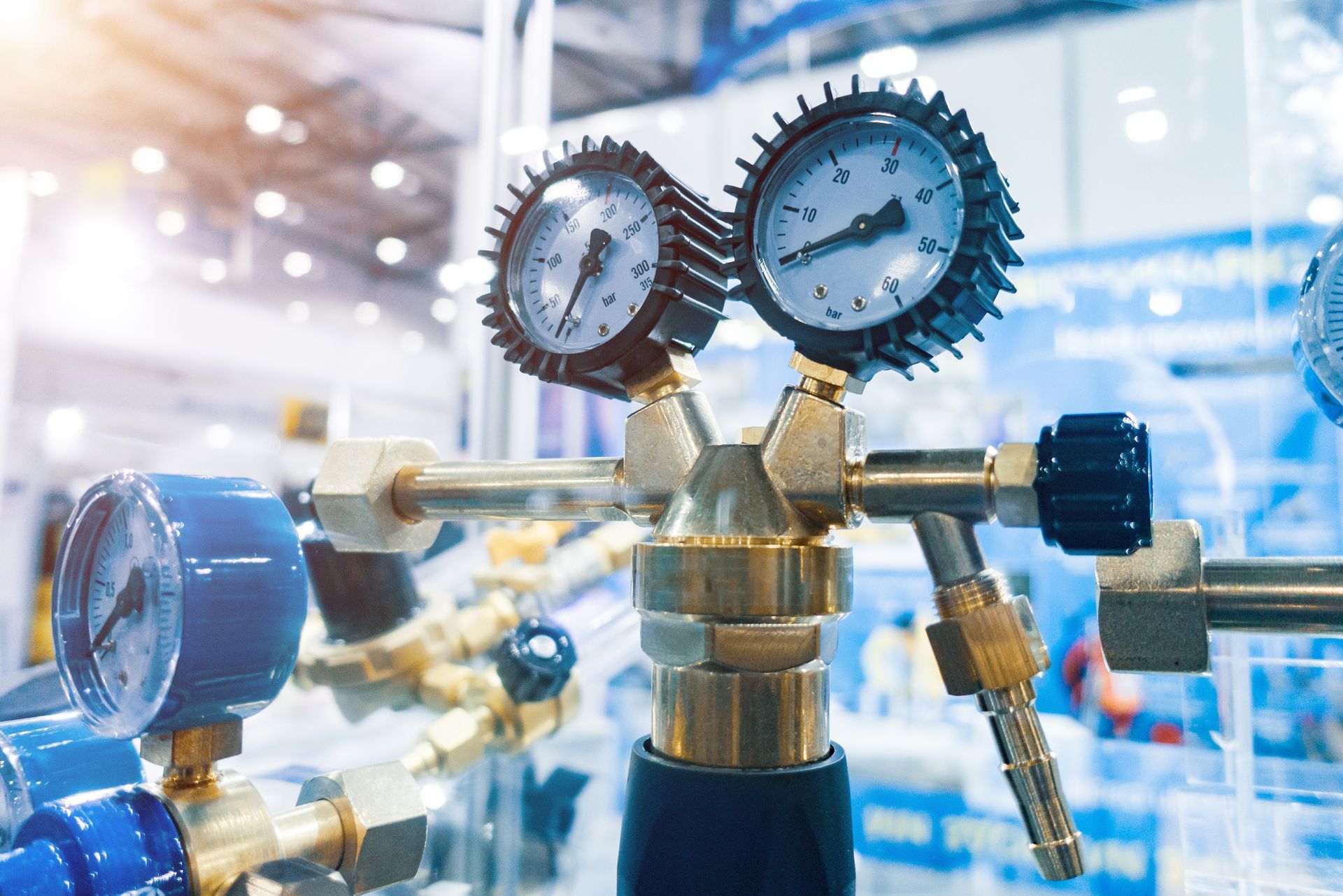 Industrial pressure gauges on brass valves in a bright factory setting