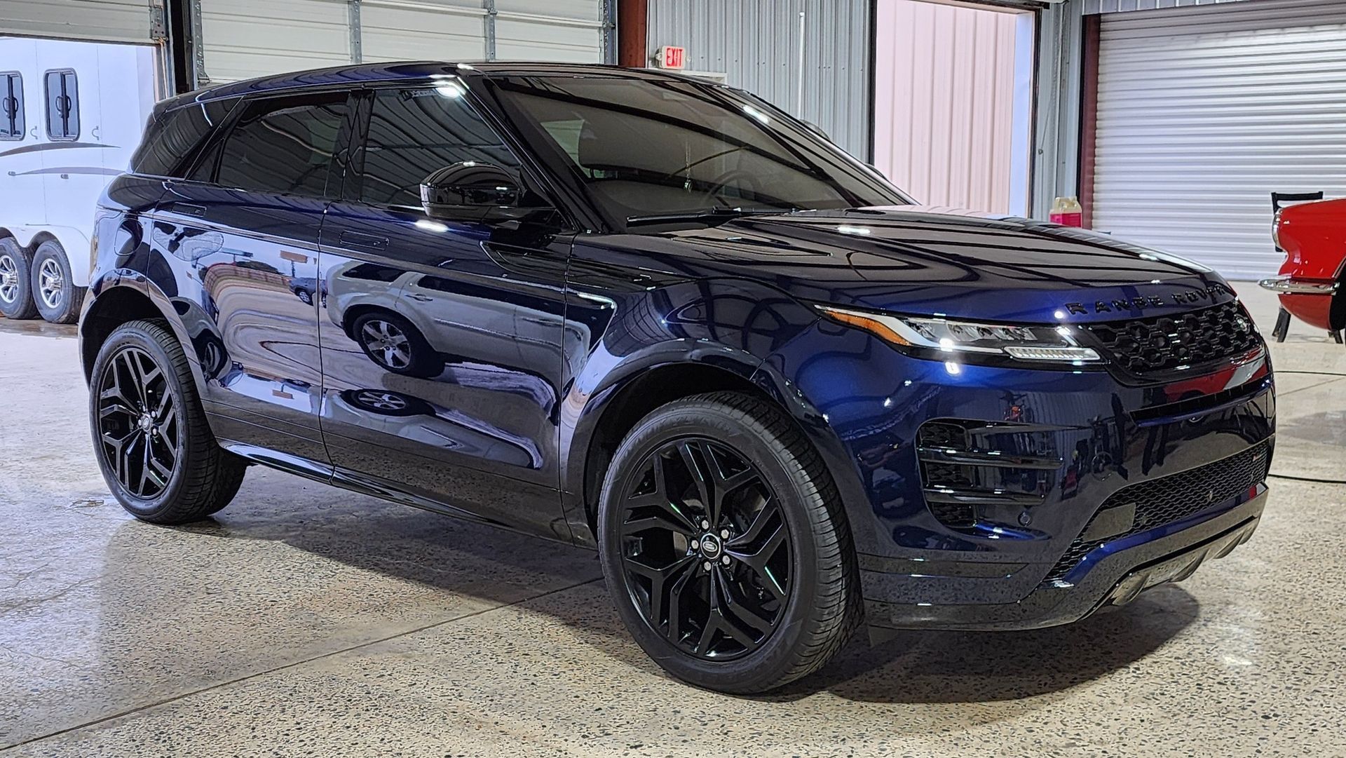Dark blue SUV with black rims parked in a garage.