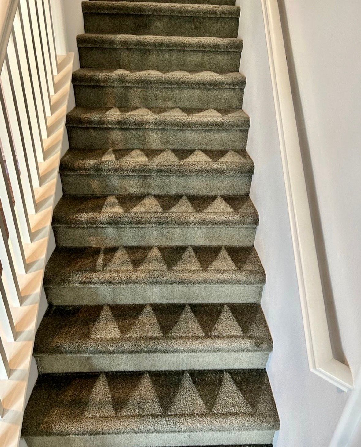 A set of stairs with a carpeted floor and a railing