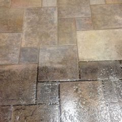 A tiled floor with a few spots of water on it