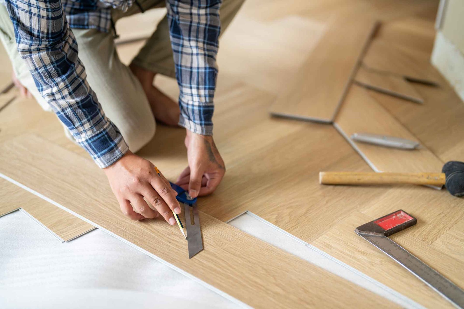 A man is cutting a piece of wood with a saw.