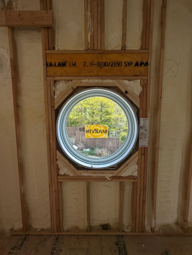 A round window is being installed in a wall.