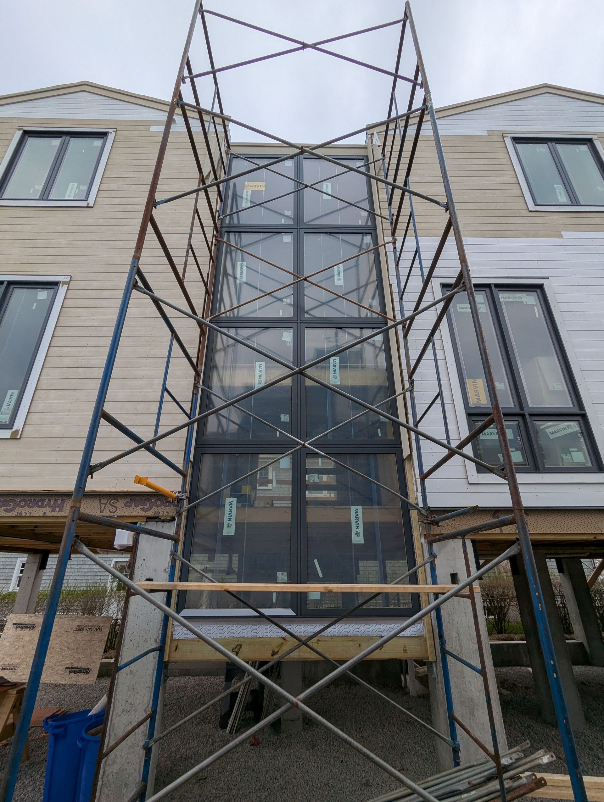 Scaffolding around a townhouse entryway between two beige brick buildings