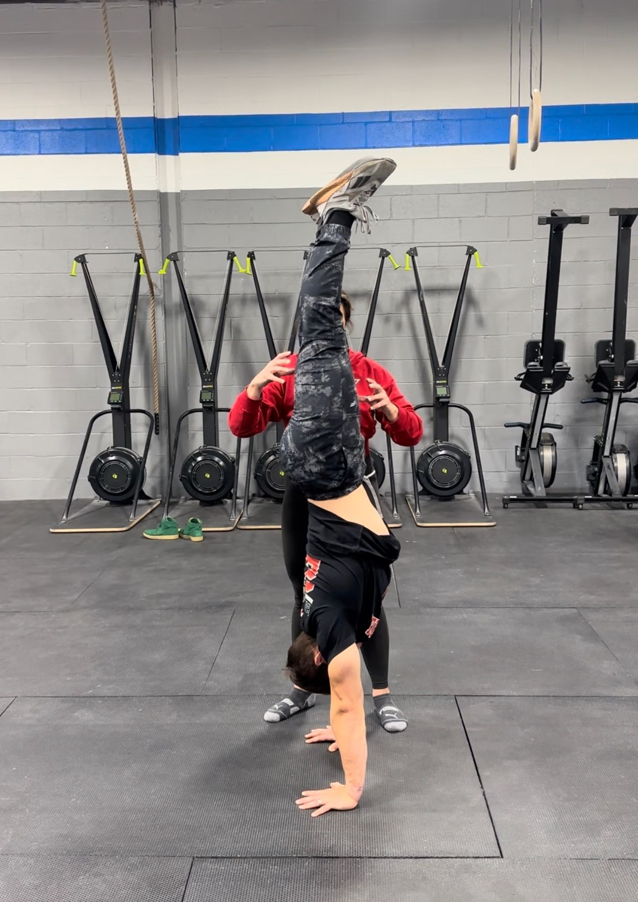 A person is doing a handstand in a gym.