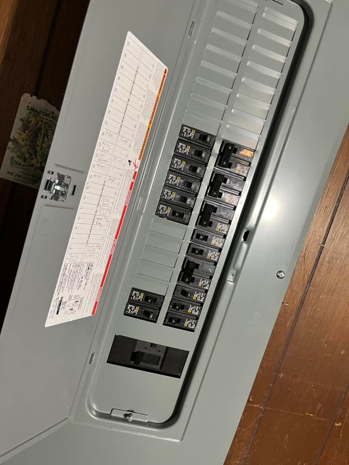 Open electrical breaker panel with switches and a circuit directory label.