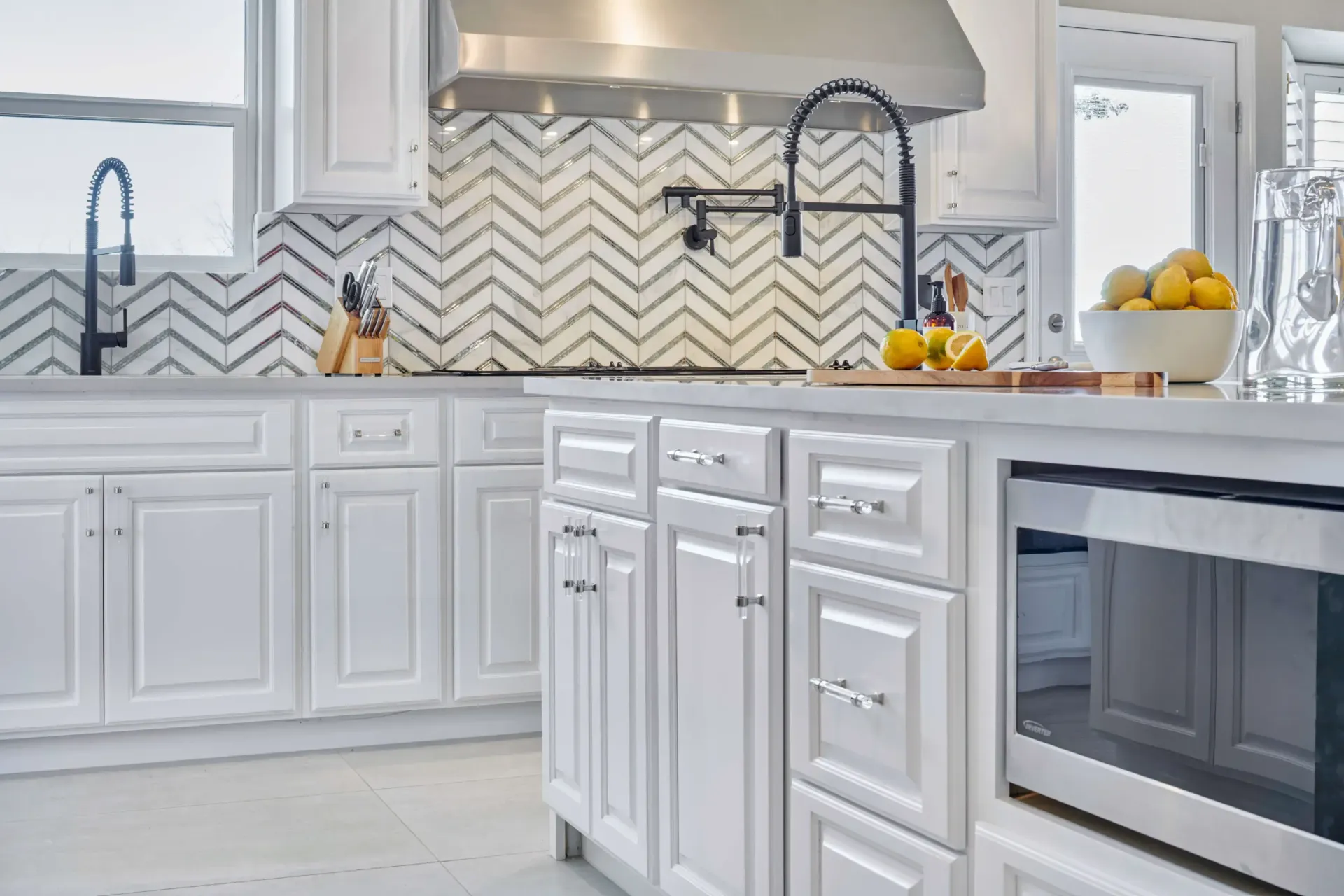 White kitchen with island, backsplash, and appliances.