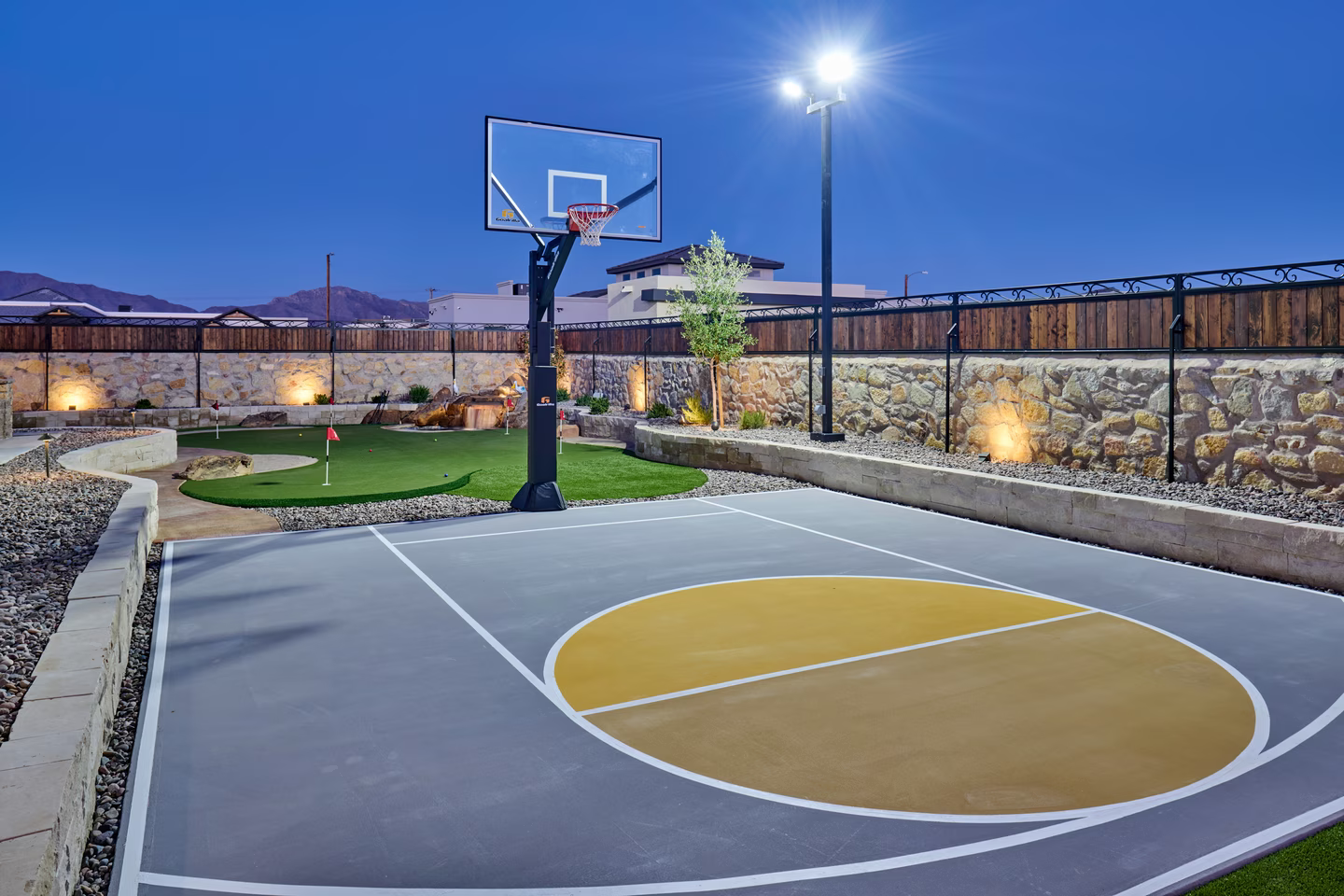 Basketball court and putting green with night lighting.
