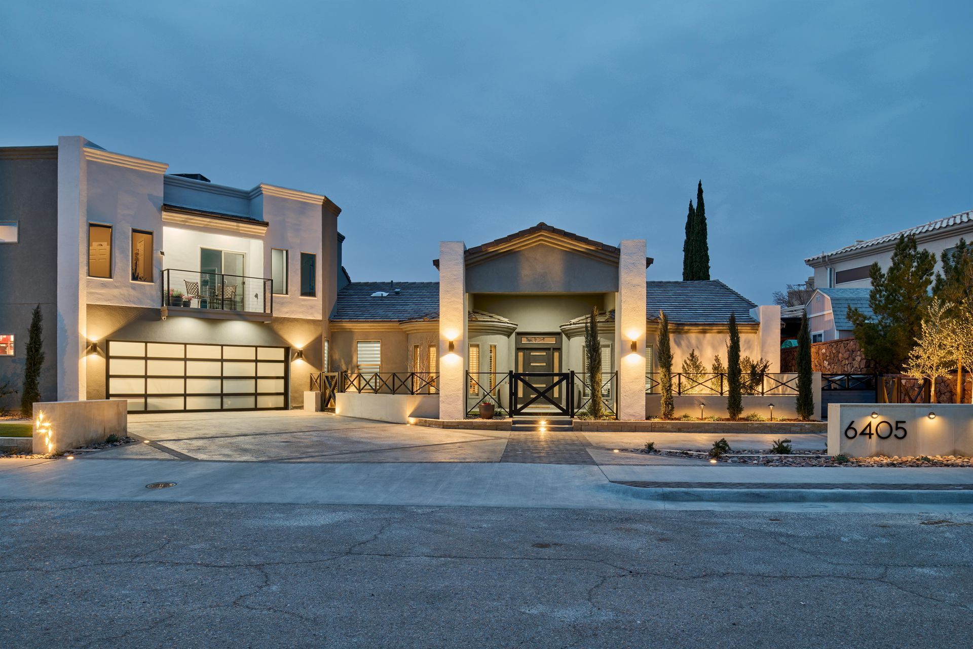 Modern house exterior at dusk with illuminated features and address