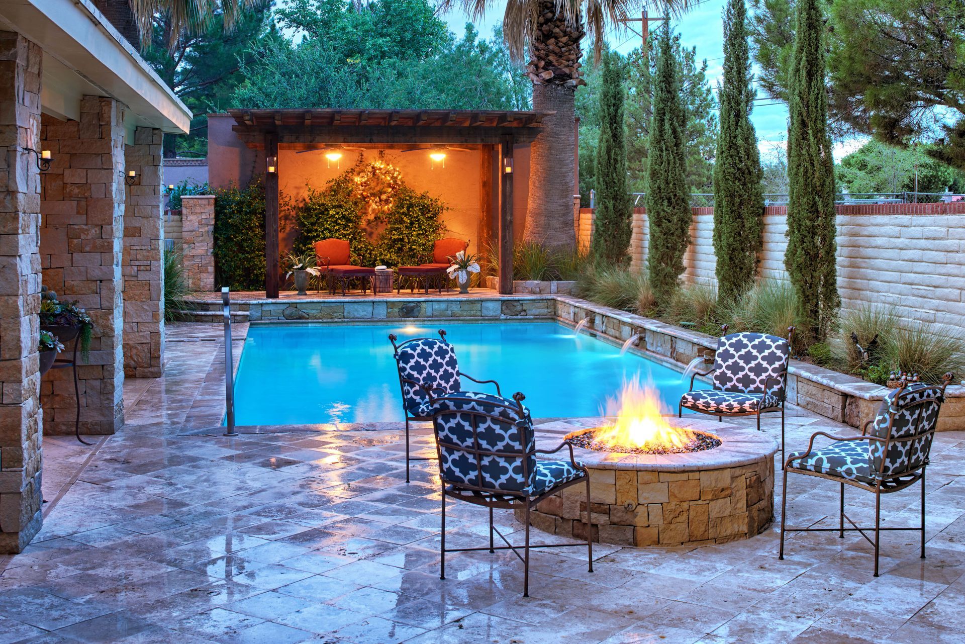 Outdoor pool area with a fire pit, seating, and a shaded lounge area.
