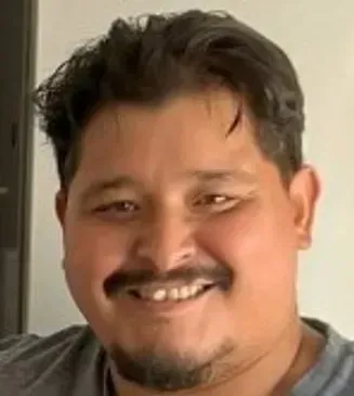 A man with a beard is smiling for the camera.
