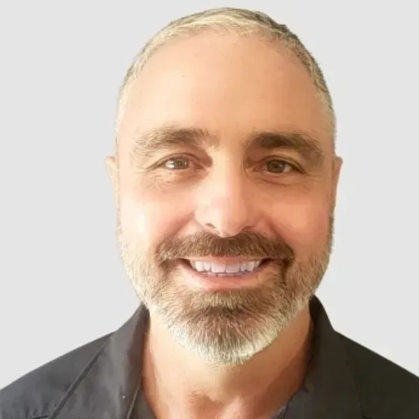 A man with a beard and mustache is smiling for the camera.
