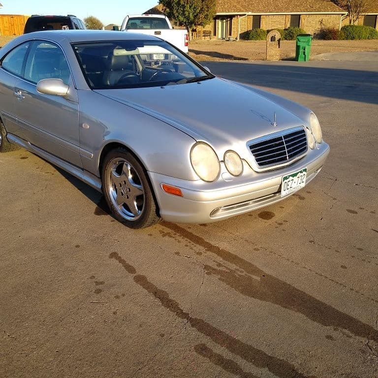 Silver Mercedes coupe parked on asphalt. Colorado license plate, sunny day.
