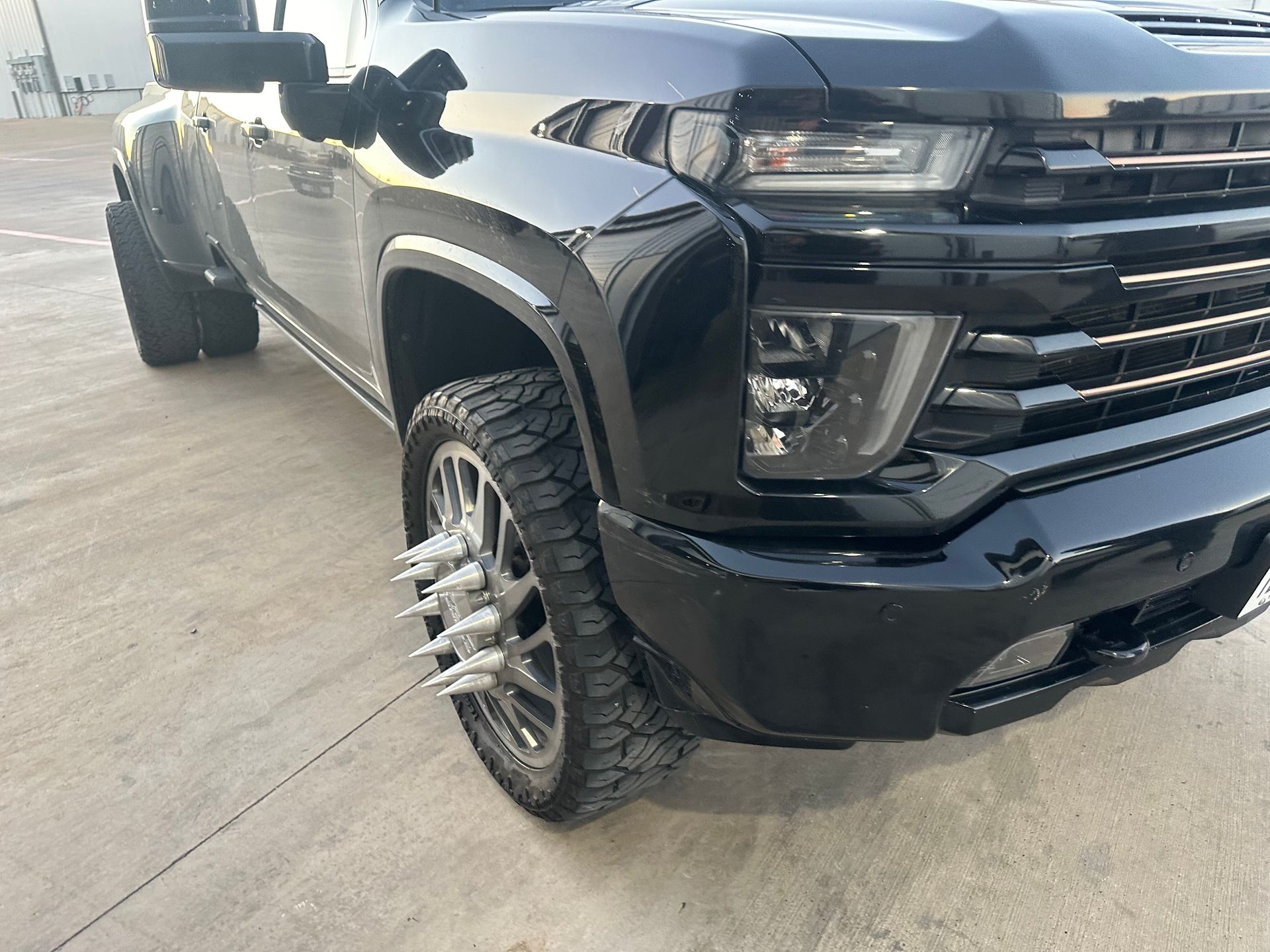 Black Chevrolet truck with dually wheels and spiked rims.