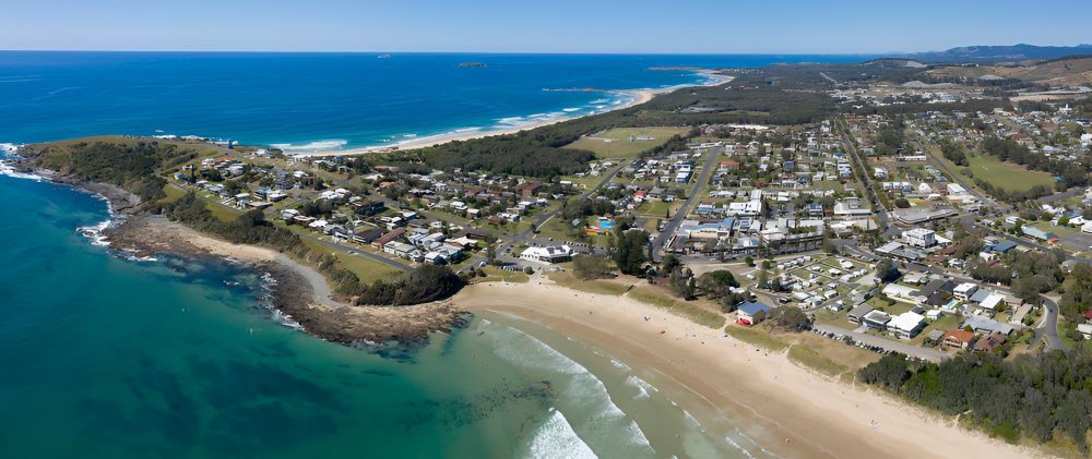 An Aerial View of A Beach with A City in The Background — Nick Locke Monuments in Woolgoolga, NSW