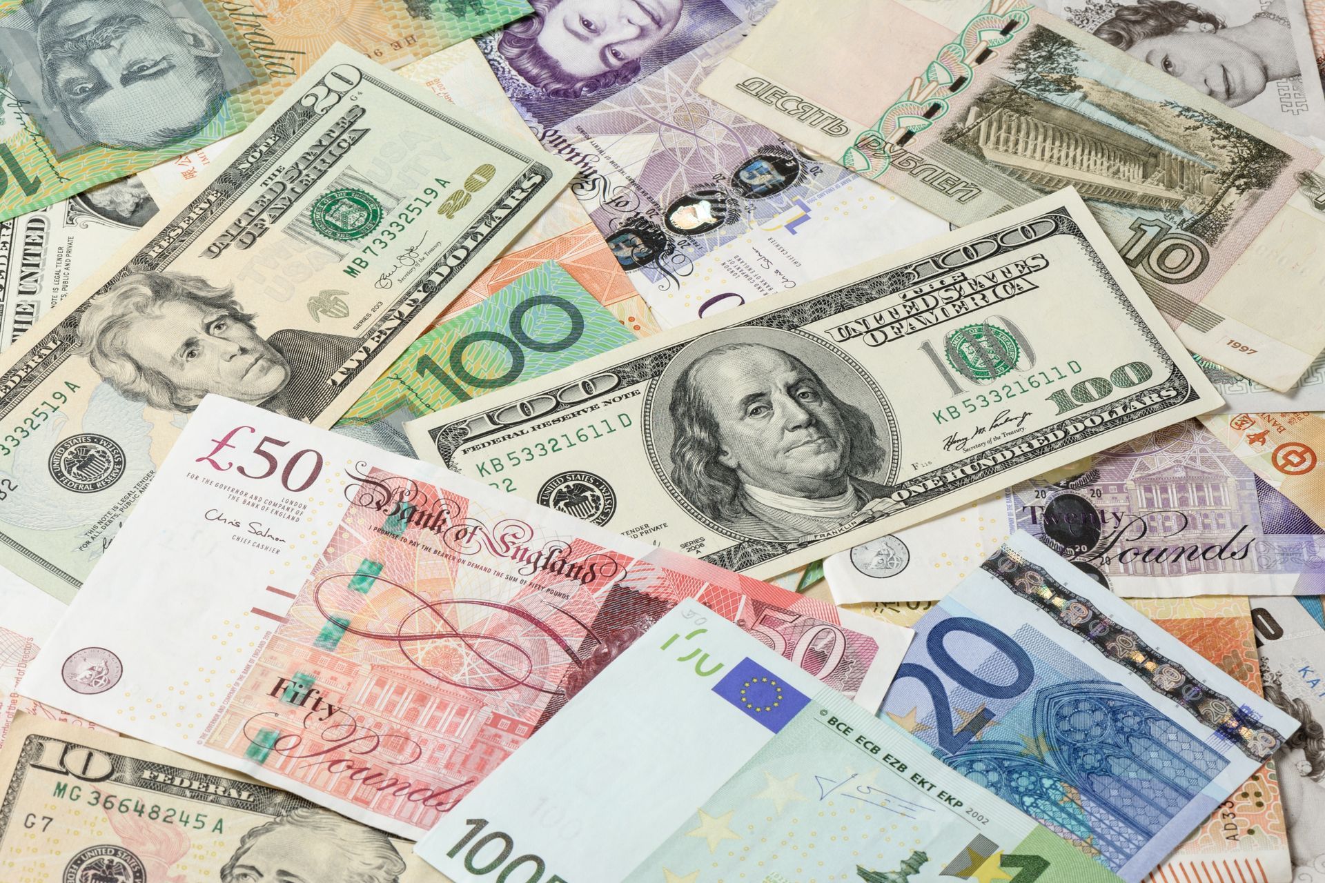 Scattered international banknotes including US dollars, British pounds, and Euros.
