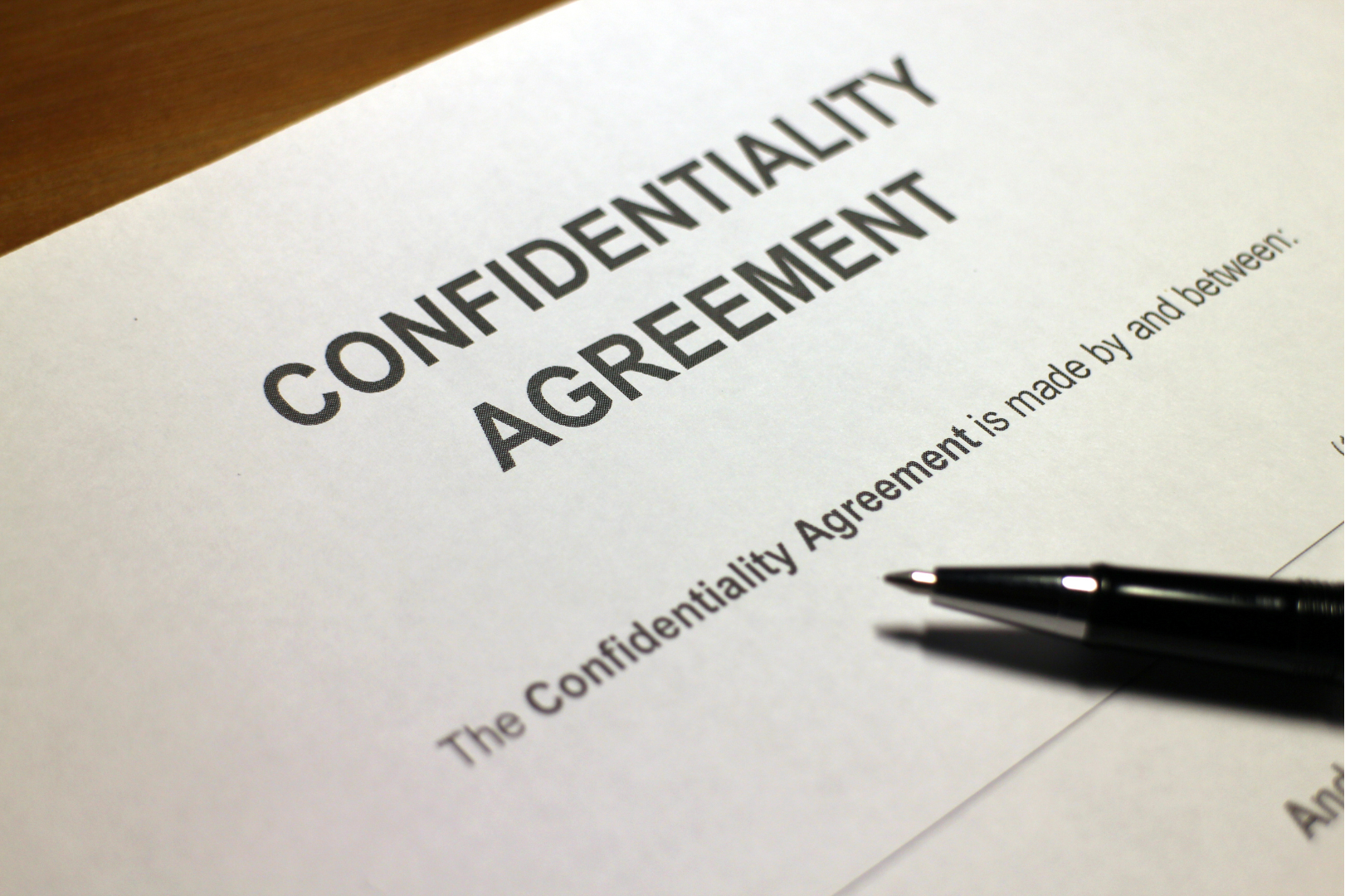 Confidentiality agreement document with a pen resting on top.