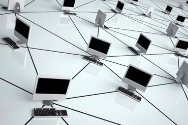Rete di computer portatili collegati tra loro su sfondo bianco.