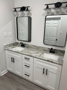 A bathroom with two sinks and two mirrors.