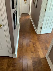 A hallway with hardwood floors and white doors in a house.