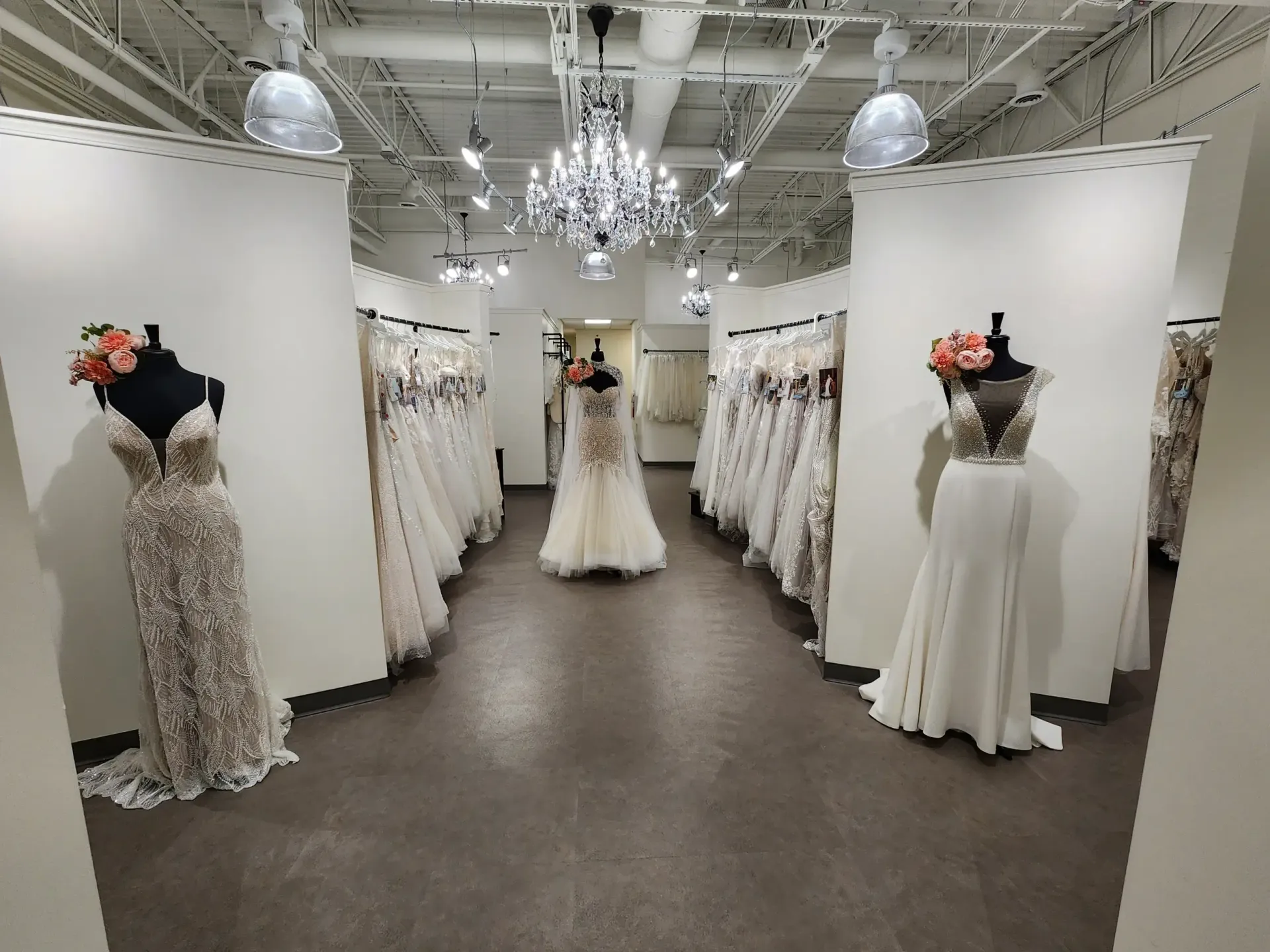 Wedding dress shop with gowns on display, three mannequins in foreground.