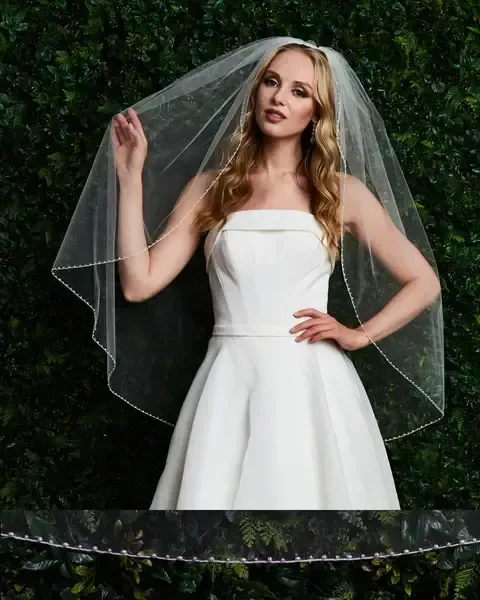 Woman in a white lace corset-style dress, partially visible, looking down.