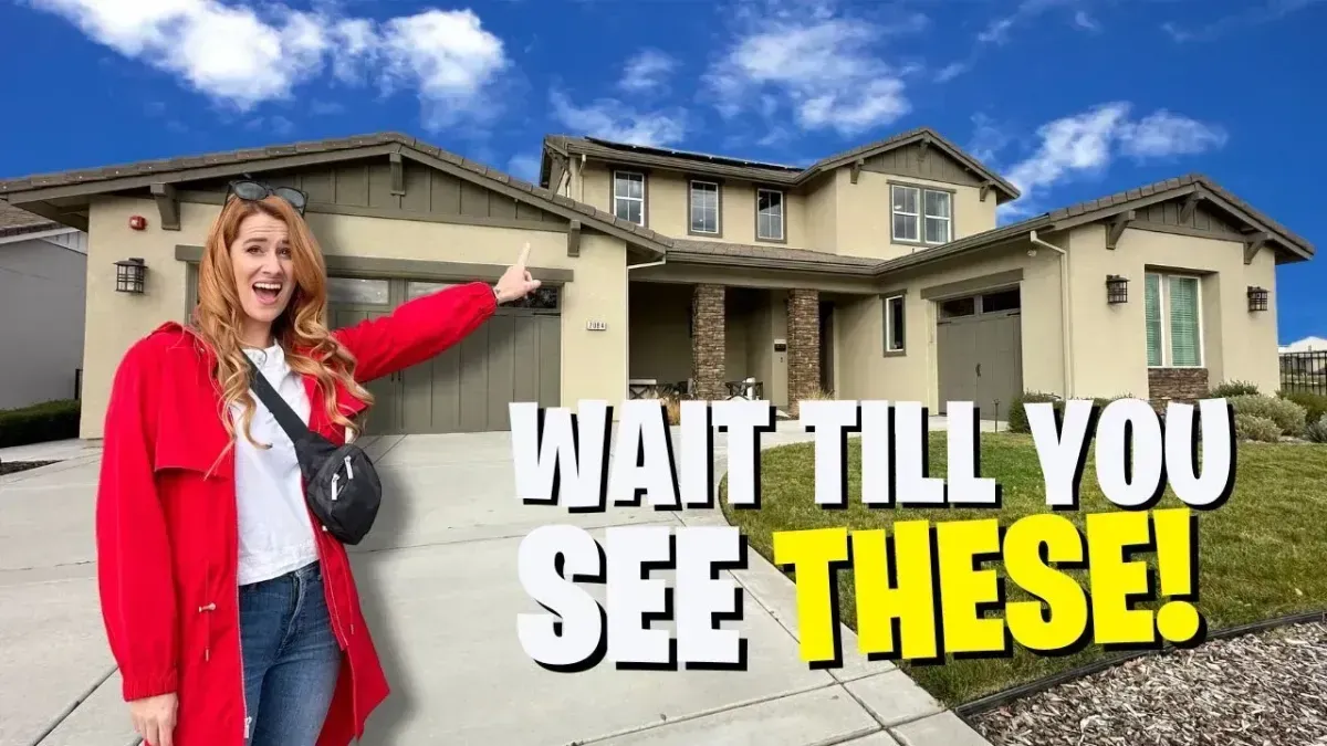 Woman in red coat pointing at a large beige house with bold text: “WAIT TILL YOU SEE THESE!”