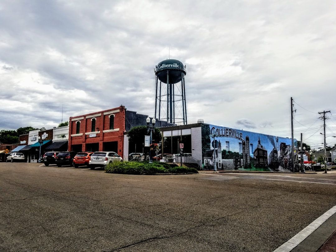 Street corner with colorful buildings and a tall water tower under a cloudy sky