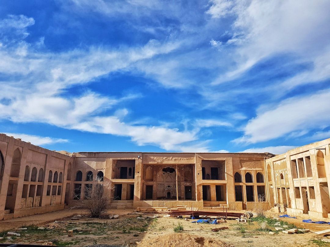 brown concrete building under blue and white sky at daytime