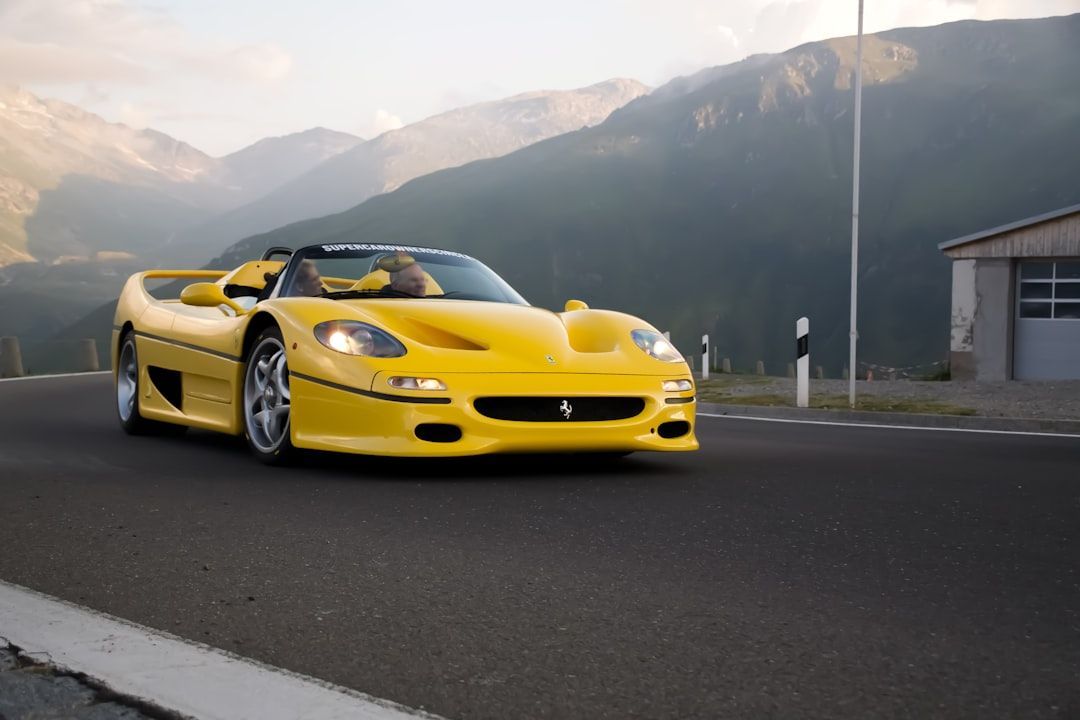 Yellow sports car on a mountain road with misty hills in the background