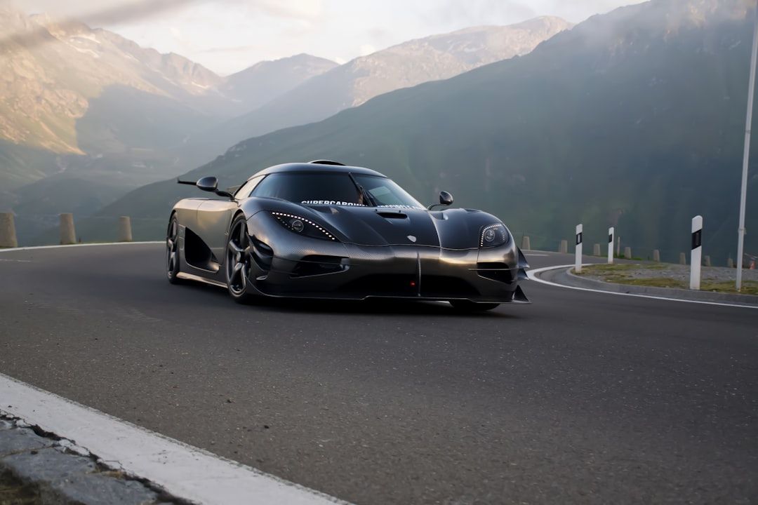 Black sports car driving on a mountain road at dusk