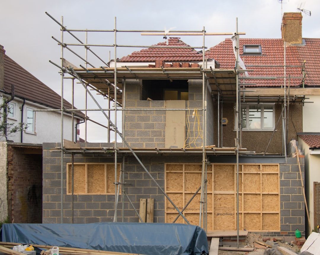 House renovation with scaffolding and boarded-up facade under construction