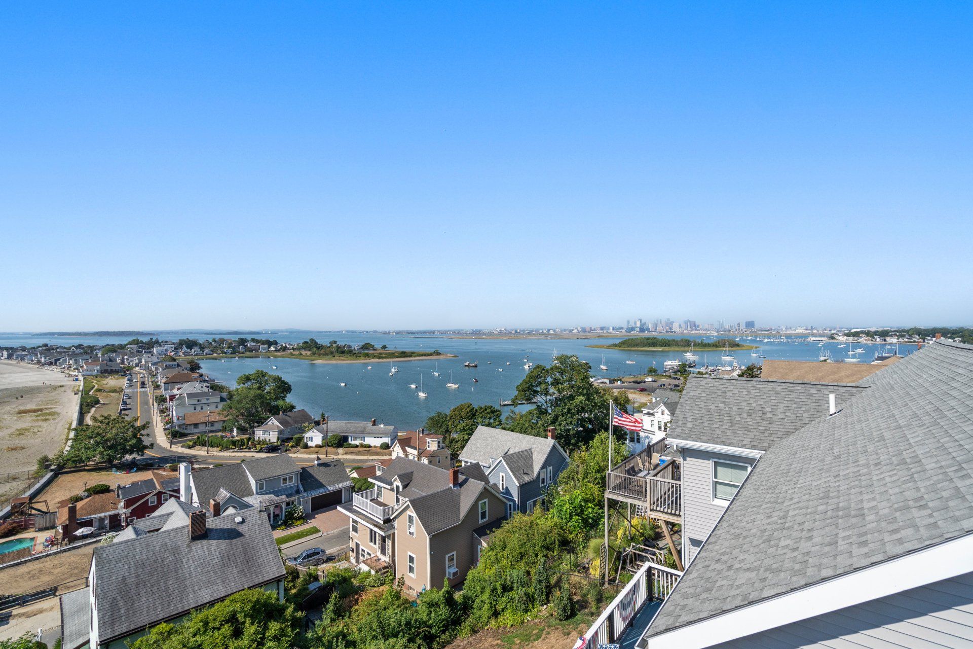 An aerial view of a residential area with a body of water in the background.