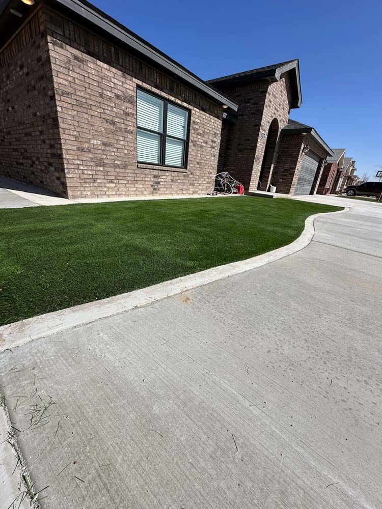 A brick house with a lush green lawn in front of it.