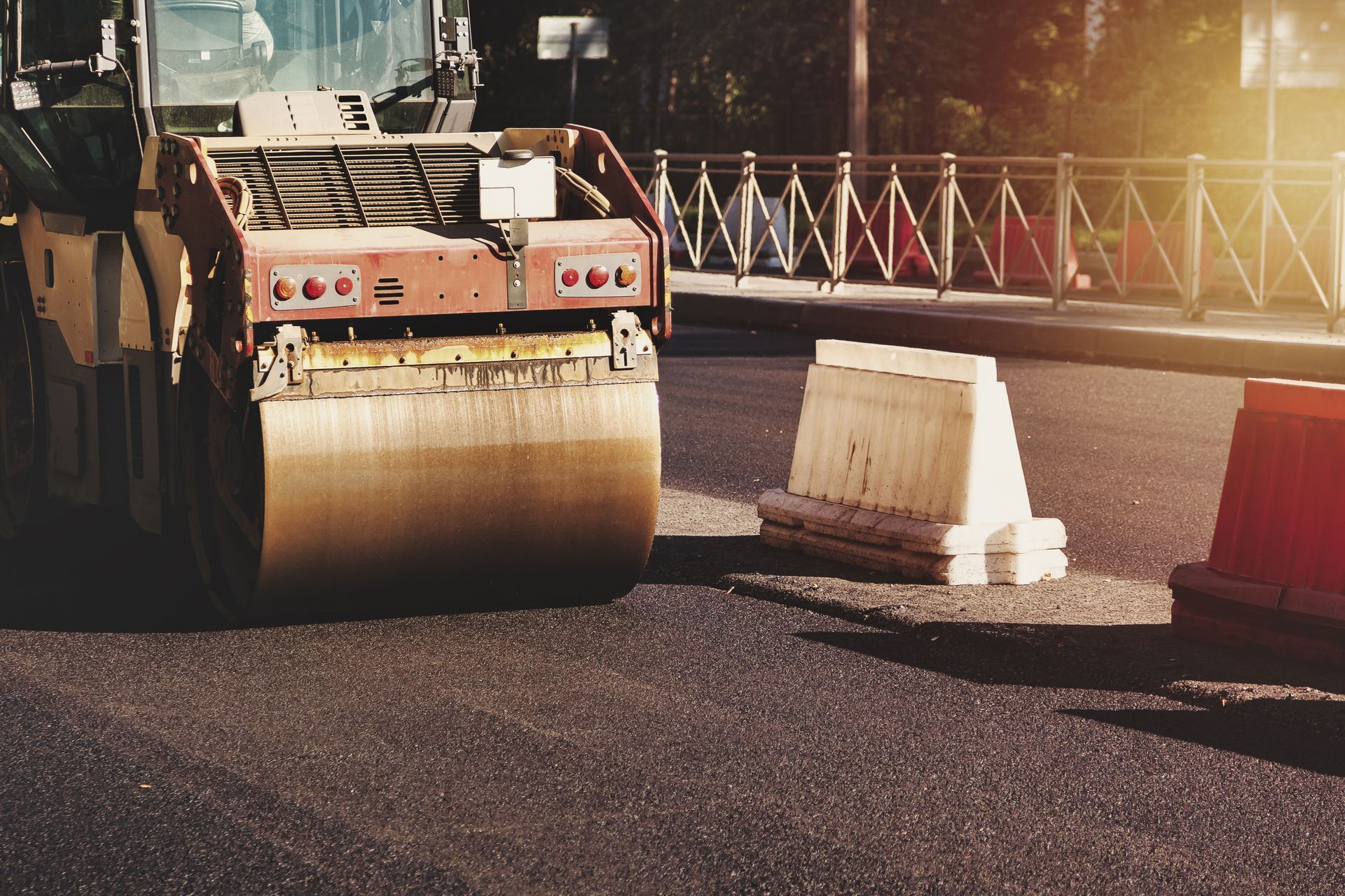 Road roller compacting freshly paved asphalt during a street resurfacing project.