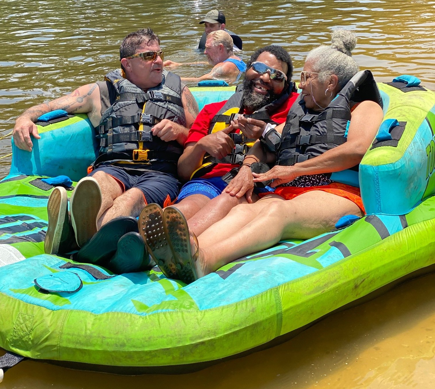 A group of people are sitting on a raft in the water.