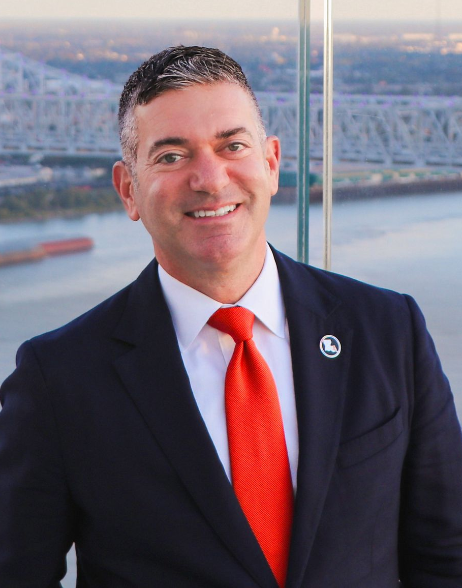 A man in a suit and tie is smiling for the camera.