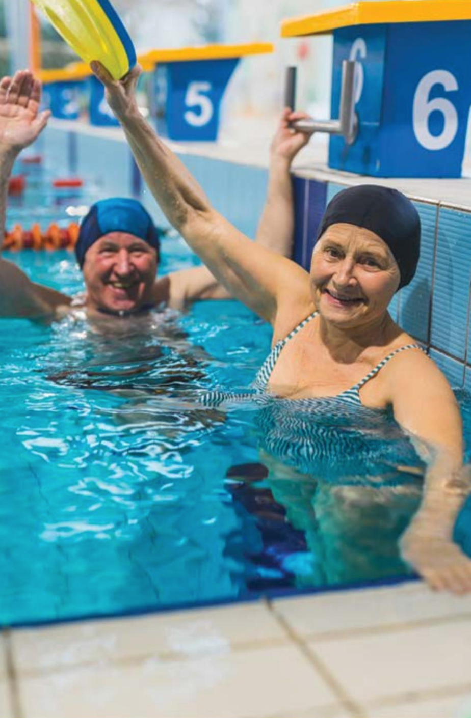 A man and a woman are swimming in a swimming pool.
