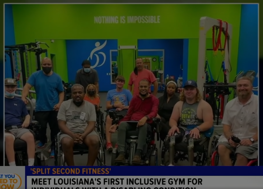 A group of people in wheelchairs are standing in a gym.