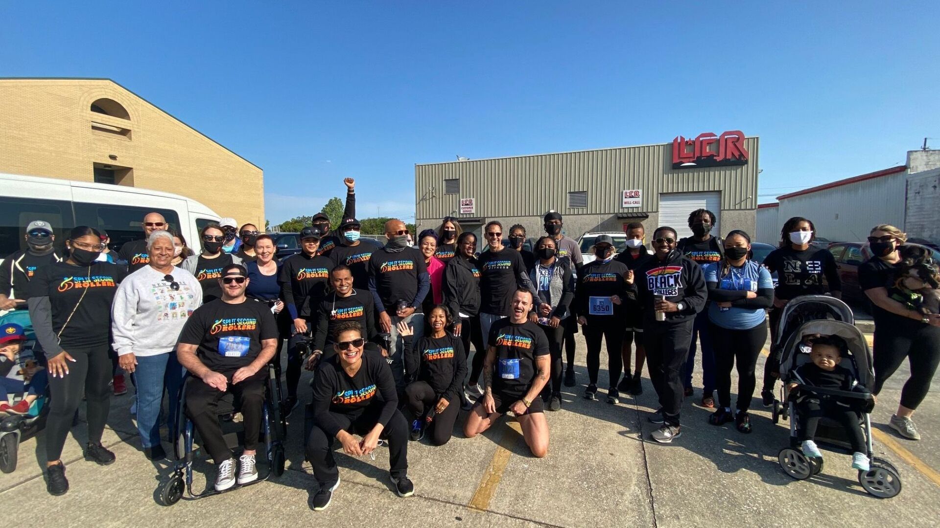 A large group of people are posing for a picture in front of a building.