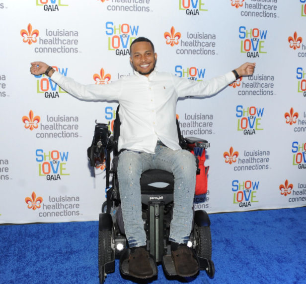 A man in a wheelchair with his arms outstretched