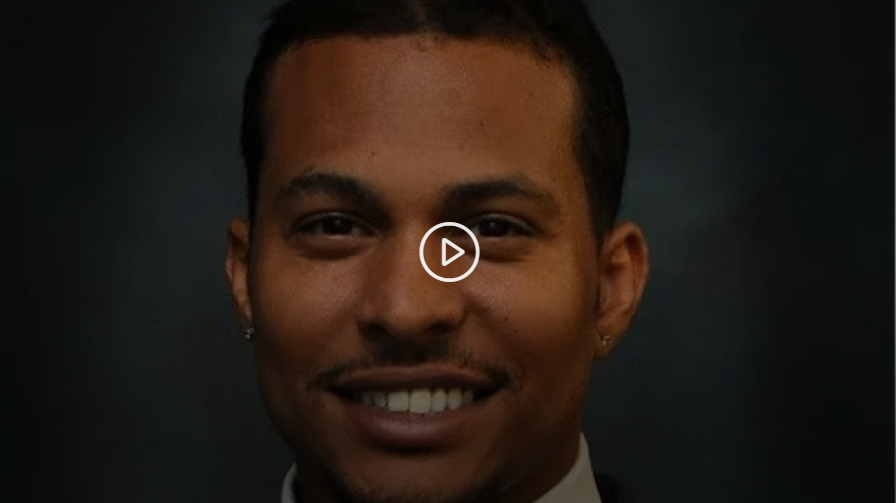 A man is smiling with a play button on his face.