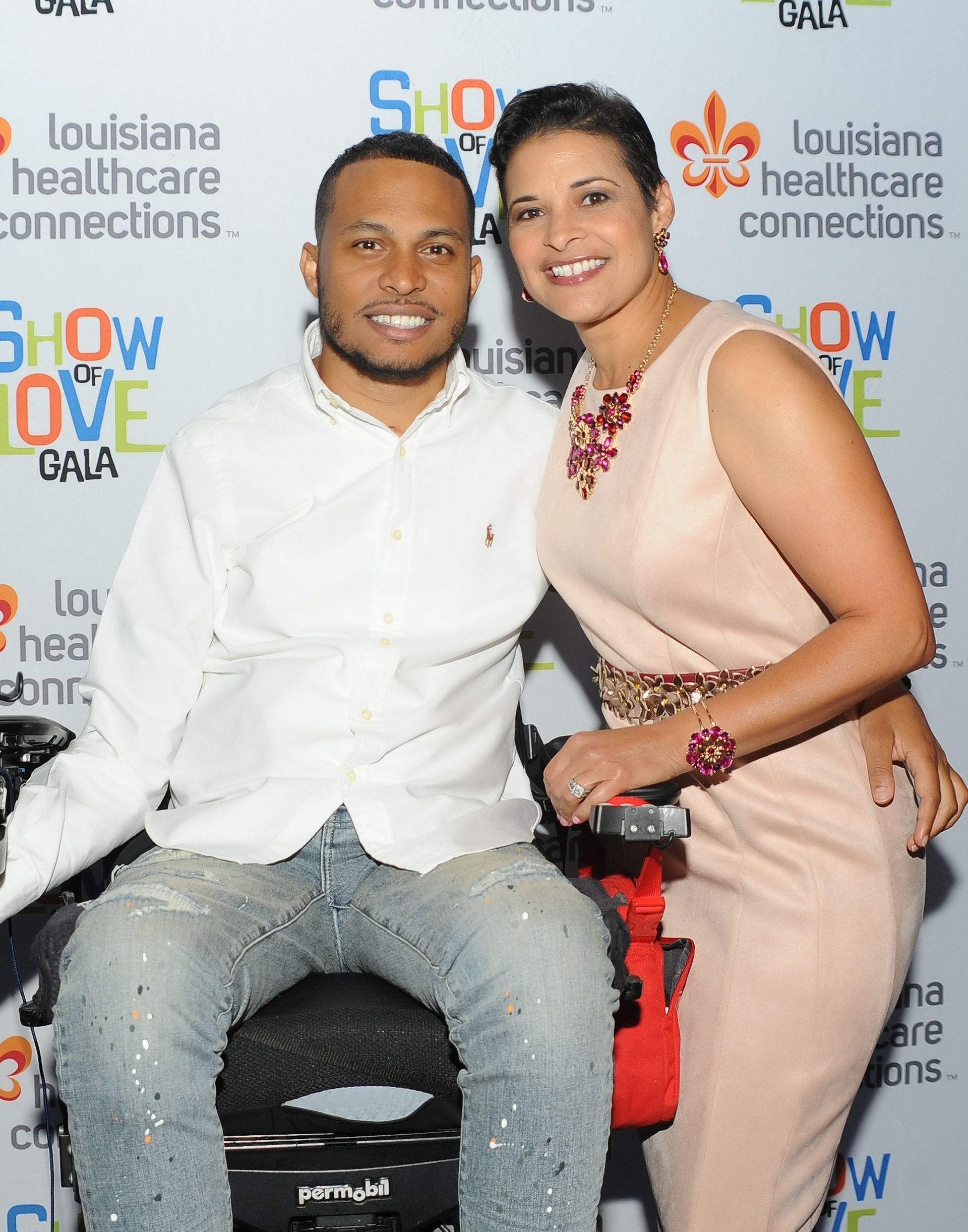 A man in a wheelchair is posing for a picture with a woman