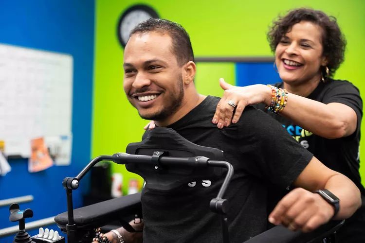 A woman is helping a man in a wheelchair.