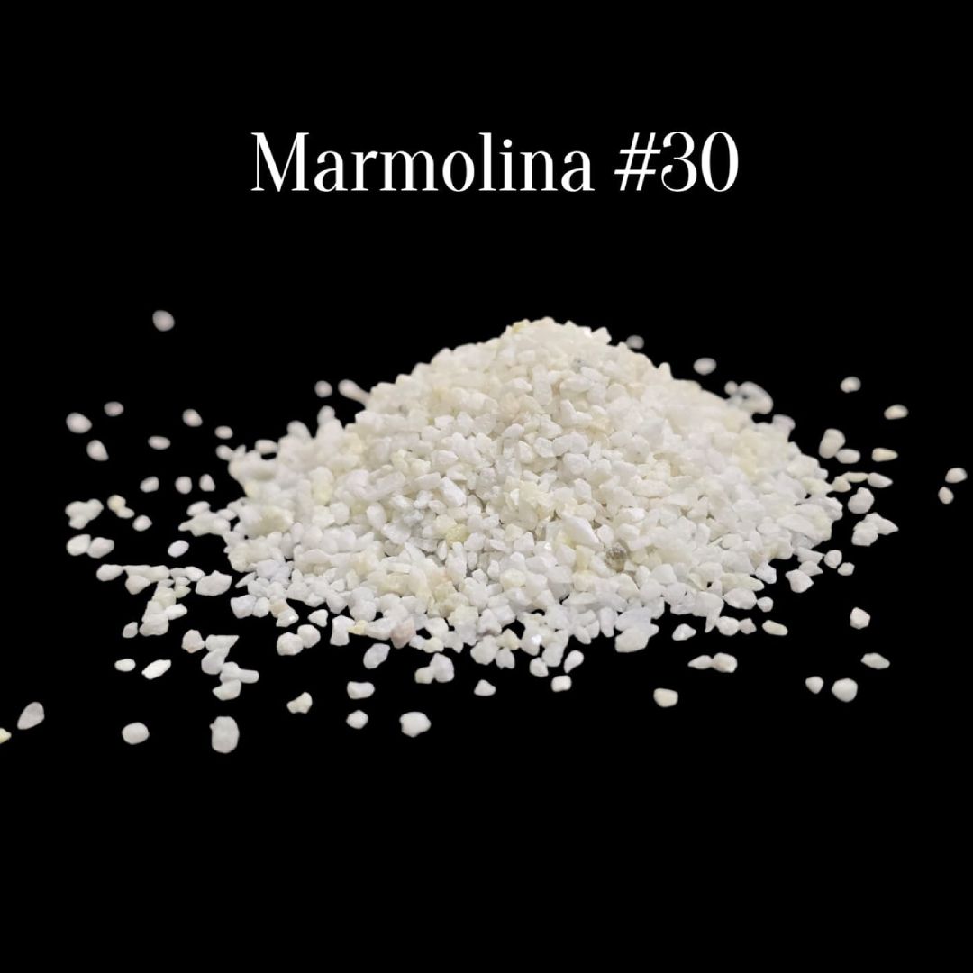 Gránulos blancos etiquetados como «Marmolina #30» sobre un fondo negro, esparcidos alrededor de un pequeño montón