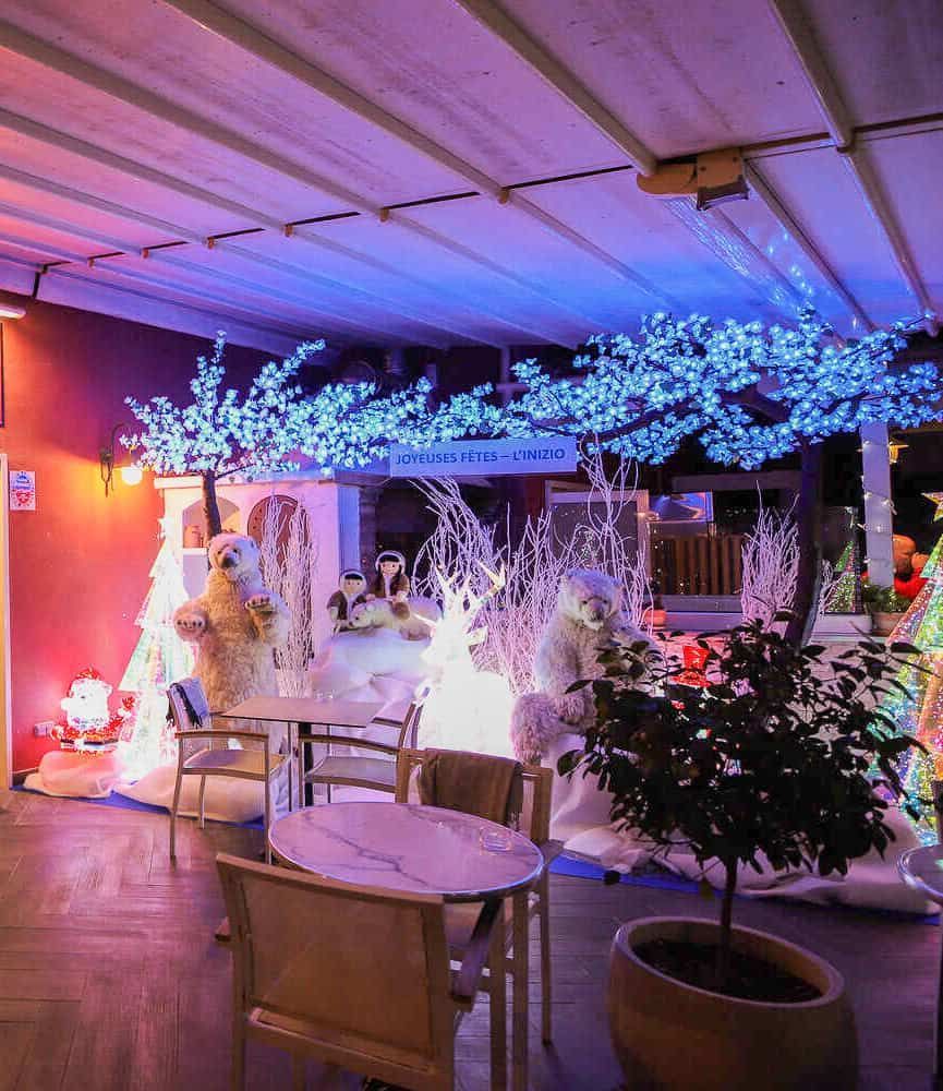 La terrasse d'un restaurant en plein air est décorée pour l'hiver avec des cerisiers en fleurs d'un bleu éclatant, des figurines d'ours polaires et de la neige.