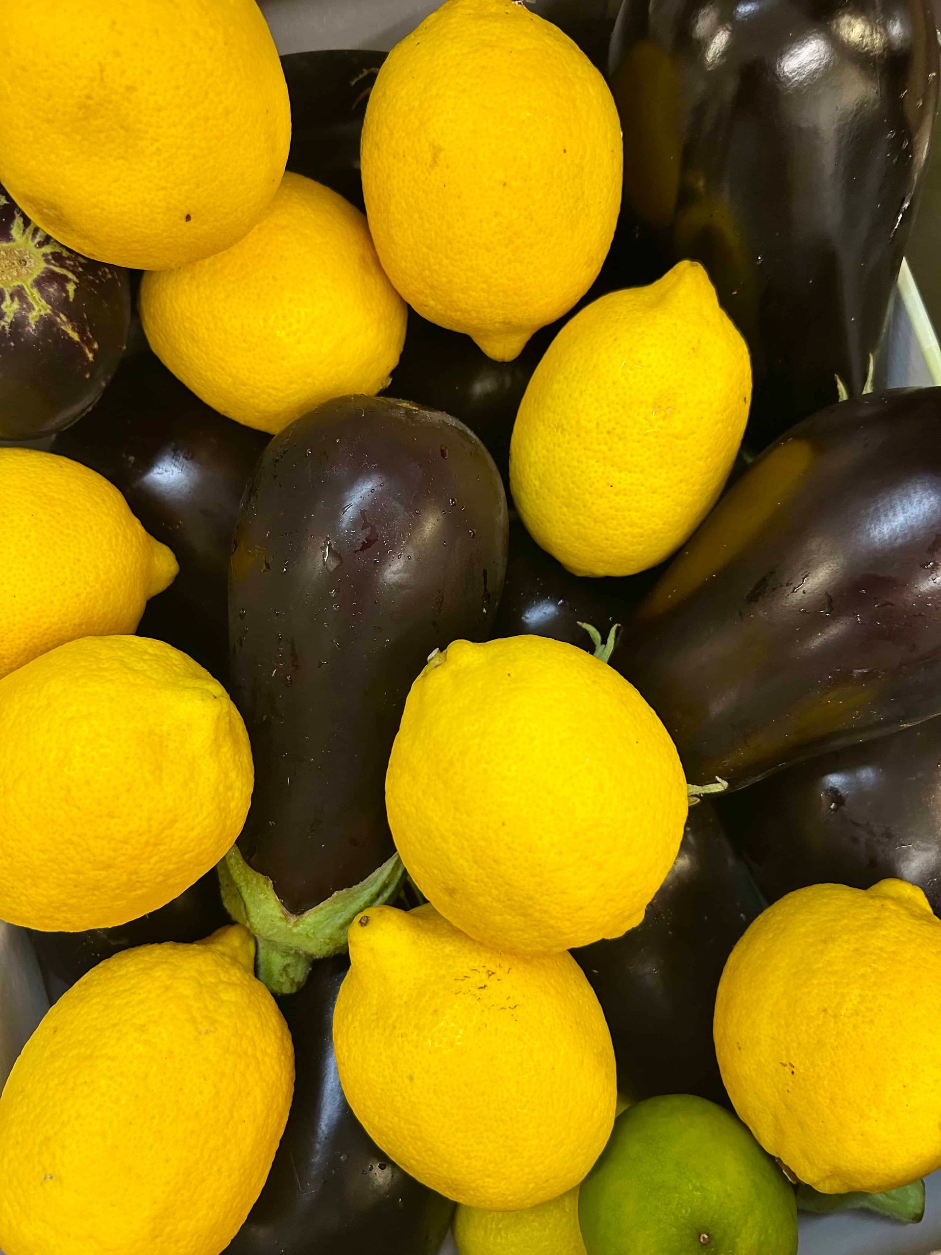 Un bouquet de citrons jaune vif et d'aubergines violet foncé serrés les uns contre les autres.